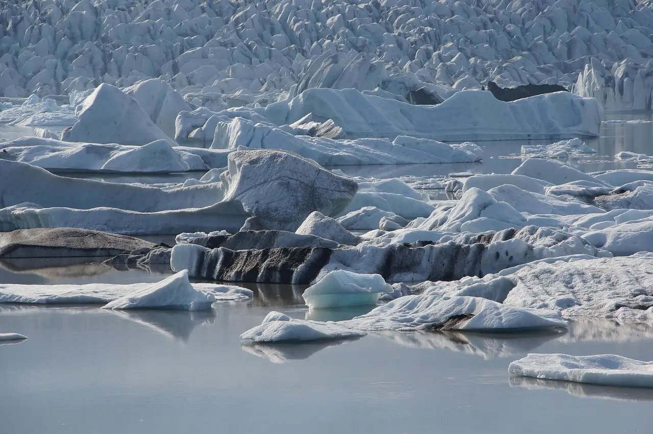 Icebergs flottant sur le lagon glaciaire de Jökulsárlón en Islande, devant les montagnes enneigées