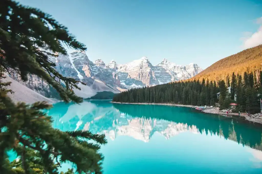 Voyage au Canada : lac Moraine, sapins et montagnes enneigées au printemps