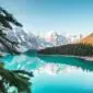 Voyage au Canada : lac Moraine, sapins et montagnes enneigées au printemps