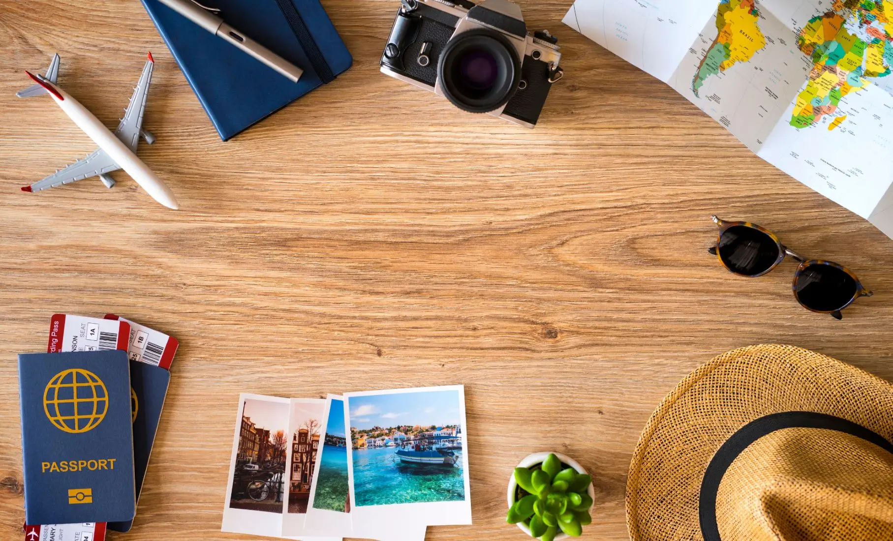 Vue à plat des accessoires indispensables pour voyager léger : passeport, billet d'avion, carnet, plan du monde.