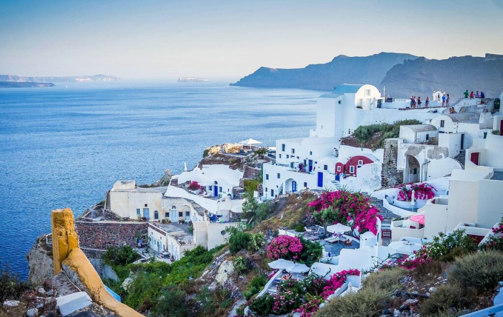 Vue panoramique de Santorin avec maisons blanches, dômes bleus et mer Égée en arrière-plan - Les Cyclades