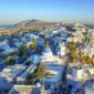 Vue aérienne sur les maisons blanches et les églises aux dômes bleus de Santorin - Santorin en couple
