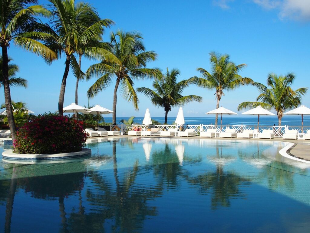 Piscine d’hôtel luxueux avec vue sur la mer et palmiers à l’Ile Maurice all inclusive
