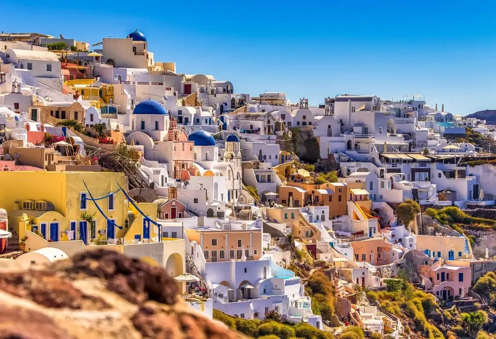 Vue panoramique de Santorin avec ses maisons blanches et dômes bleus sous un ciel d'été - quand partir à Santorin