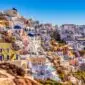 Vue panoramique de Santorin avec ses maisons blanches et dômes bleus sous un ciel d'été - quand partir à Santorin