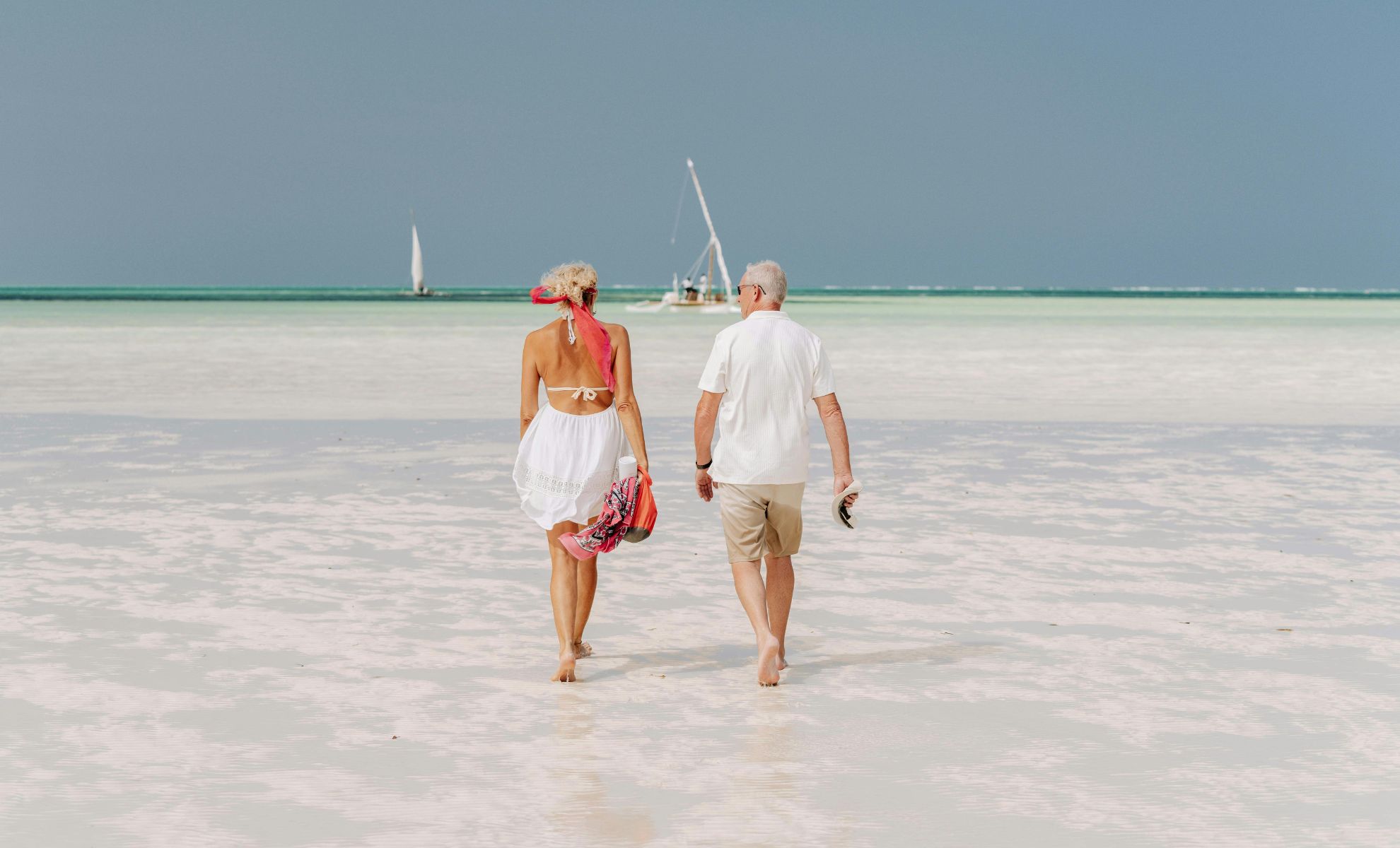 Couple marchant sur la plage de Zanzibar au coucher du soleil - meilleurs hôtels à Zanzibar en couple