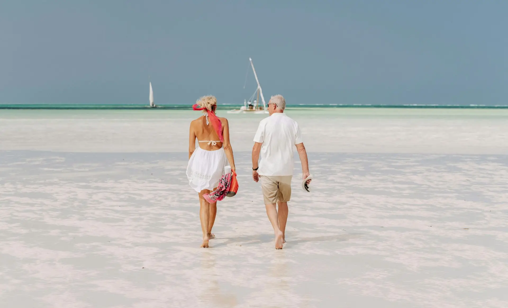 Couple marchant sur la plage de Zanzibar au coucher du soleil - meilleurs hôtels à Zanzibar en couple